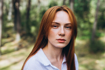 Fototapeta premium Beautiful woman natural face freckles casual female portrait lifestyle beauty girl. Outdoor girl portrait in green summer forest