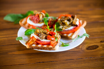 Prepared sandwich with tomatoes, mozzarella and fried eggplant with mushrooms.