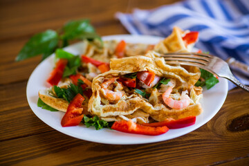 Fried simple omelet with shrimp and vegetables in a plate.