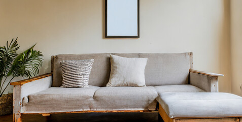 rustic sofa with white cushions next to accent end table against beige wall with empty mock 