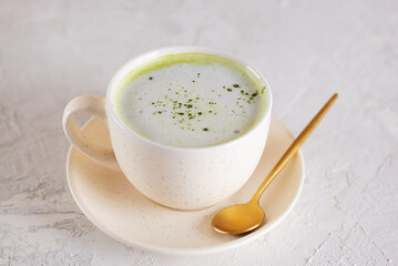 Vegan green matcha latte drink with coconut milk in a cup. Healthy drink, lactose, gluten and sugar free.
