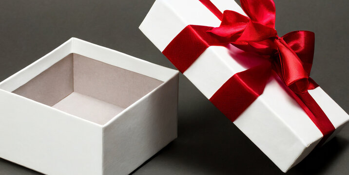 white present box open or white gift box with red ribbons and bow isolated on dark gray back 