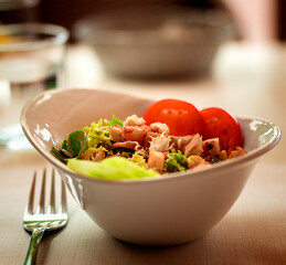 Fresh vegetable salad, a beautiful porcelain plate on the table in the restaurant. homemade food