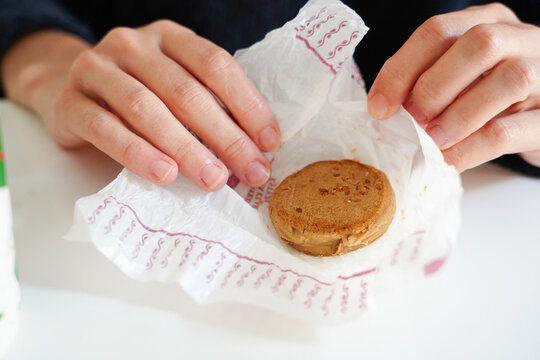 Unrecognizable female wrapping polvoron in paper for celebrating Christmas