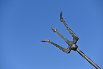 Partial view to neptune's trident in front of the blue sky.