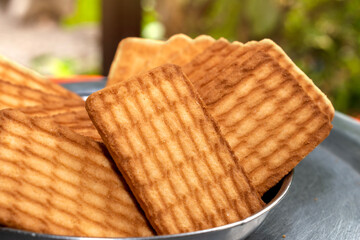 Brown Wheat biscuits in the steel plate with blury background. Tea Biscuit morning breakfast