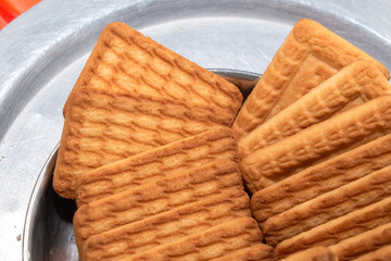 Brown Wheat biscuits in the steel plate with blury background. Tea Biscuit morning breakfast