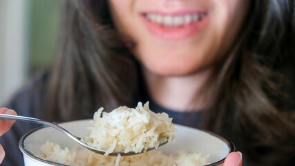 there is a woman with a bowl of rice holding a spoon
