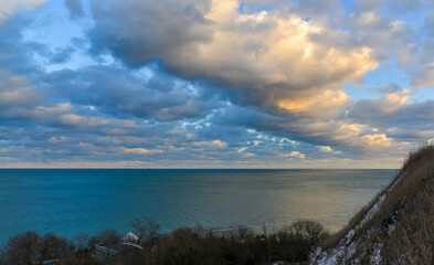 Cumulus white clouds in the evening at sunset low over the Black Sea.