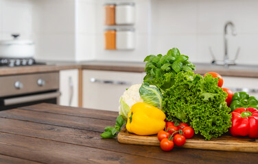 Various fresh vegetables ingredients for cooking healthy food on a wooden table in modern home kitchen, copy space