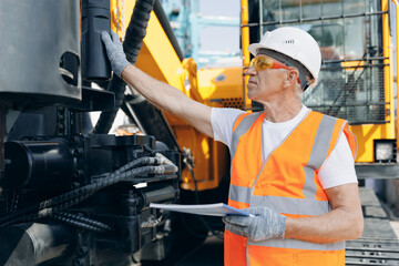 Hydraulic engineer doing safety check on new installation hoses of modern drilling industrial machine
