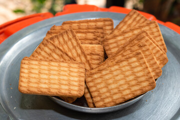 Brown Wheat biscuits in the steel plate with blury background. Tea Biscuit morning breakfast