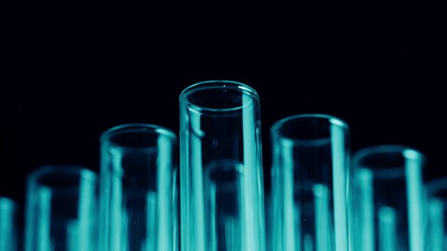 Close up video neon blue light test tubes in a laboratory. Scientific experiment, research, study. Detail shot of lab glassware.