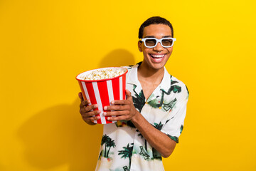 Photo of cheerful cool guy wear stylish outfit hand hold tasty popcorn enjoy comedy film isolated on vibrant yellow color background