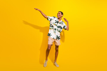 Fototapeta na wymiar Full body photo of attractive young man dancing promoting disco wear trendy palms print clothes isolated on yellow color background