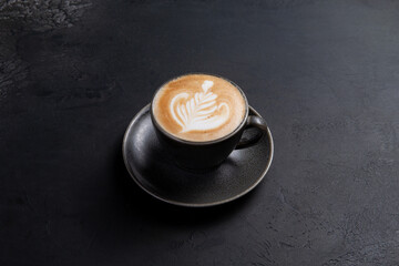 Cup of cappuccino on a dark background.