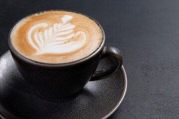 Cup of cappuccino on a dark background.