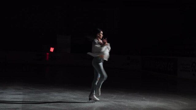 wide shot of a professional figure skater spins around super fast on the ice