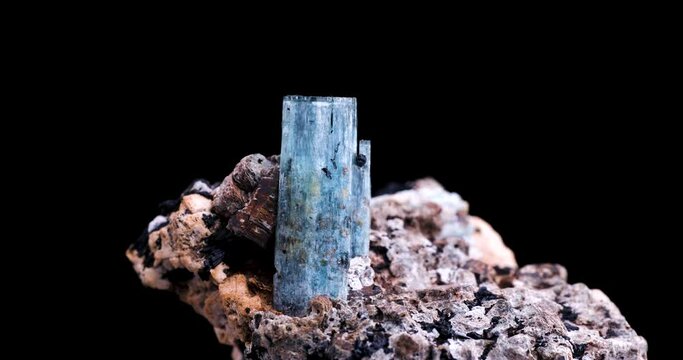 blue aquamarine with schorl (black tourmaline) inclusion rotating 360&deg; in 4k isolated on black background. macro detail close-up rough raw unpolished semi-precious gemstone.
