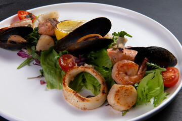 Salad with seafood on a dark background.