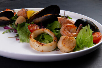 Salad with seafood on a dark background.