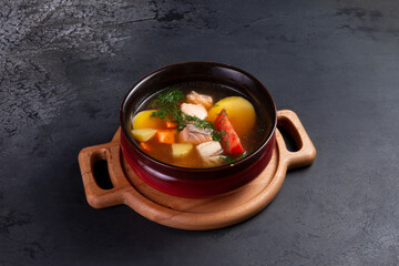 Traditional fish soup. Ear. On a dark background.