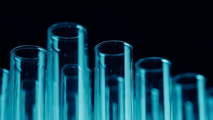 Close up photo neon blue light test tubes in a laboratory. Scientific experiment, research, study. Detail shot of lab glassware.