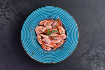 Cooked shrimp in a plate. On a dark background.