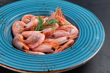Cooked shrimp in a plate. On a dark background.