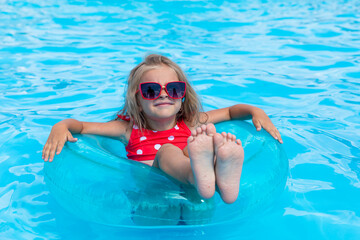 Child in swimming pool. Tropical vacation for family with kids. Little girl wearing red swimsuit playing in outdoor pool of exotic island resort. Water and swim fun for children - obrazy, fototapety, plakaty