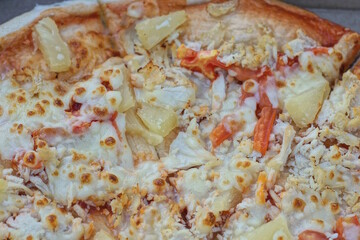 food from piece of fried pizza lies on gray paper packaging box