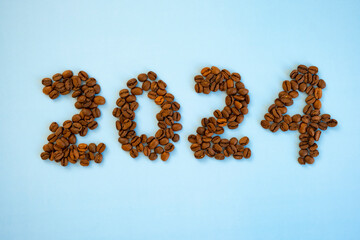 2024 number made of coffee beans and cup of coffee on light blue background as symbol of new start,...
