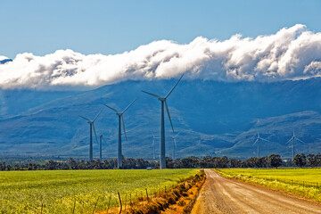 Large wind turbines with cloud covered mountain