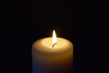 A candle flame with a dark background and copy space