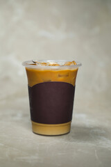 Iced Blended Caramel Coffee served in disposable cup isolated on grey background side view of cafe dessert