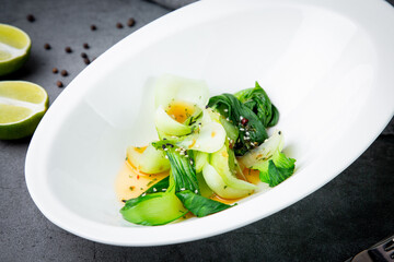 a dish of eggs and seaweed with sesame seeds and lime on the background in a beautiful plate side view