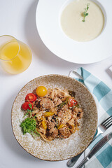 udon noodles with duck meat, herbs, sesame seeds and cherry tomatoes side view