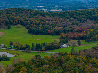 Aerial view of the countryside in Stormville, New York on a day with dark clouds, during the colorful autumn season.