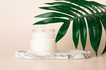 Candle on a marble stand with a green leaf, Minimalistic spa decor, Relaxing body care, top view,