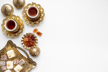Bronze tray with Arabic or Turkish tea with sweets nuts and dried fruits, top view