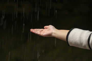 Picture of raindrops falling in the hands of a woman in an autumn season.