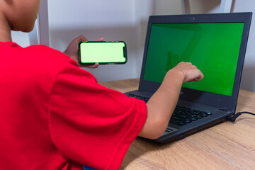 Asian boy studying online on digital tablet on desk at home. Copy space. No change. Childhood,...