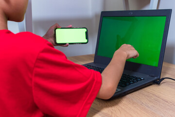 Asian boy studying online on digital tablet on desk at home. Copy space. No change. Childhood,...