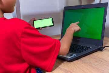Asian boy studying online on digital tablet on desk at home. Copy space. No change. Childhood,...
