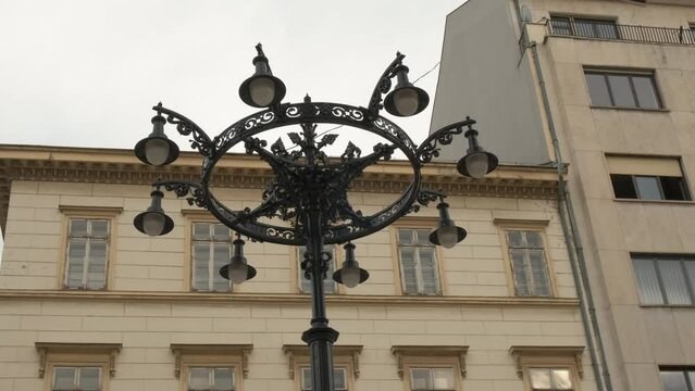 Black retro street lamp during day city. A view of black street lamp in retro style against buildings facade.