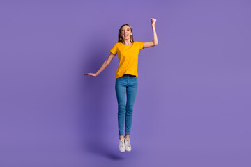 Full size photo of girl raise fists kump high up rejoicing isolated purple color pastel background