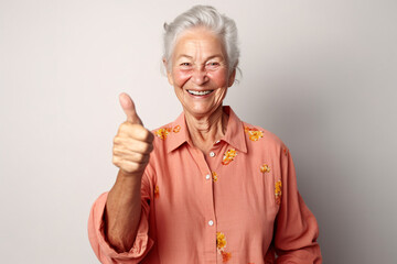 Cheerful mature woman smiling and thumbs up, close up portrait, senior lady giving positive feedback or highly recommend something.