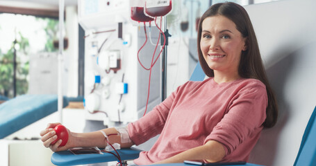 Caucasian Woman Donating Blood For People In Need In Hospital. Female Donor Squeezing Heart Shaped...