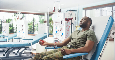 Black Male Army Soldier Donating Blood For Injured Comrades In Military Hospital. Brave African Troop Squeezing Red Heart-Shaped Ball To Pump Blood Through Tubing Into Bag. Donation For Men In Service - obrazy, fototapety, plakaty