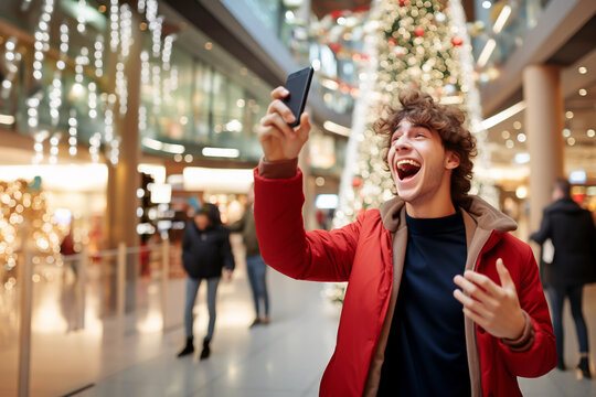 YOUNG ADULT MAN REJOICES AT A MESSAGE RECEIVED ON A SMARTPHONE IN A SHOPPING MALL. image created by legal AI
